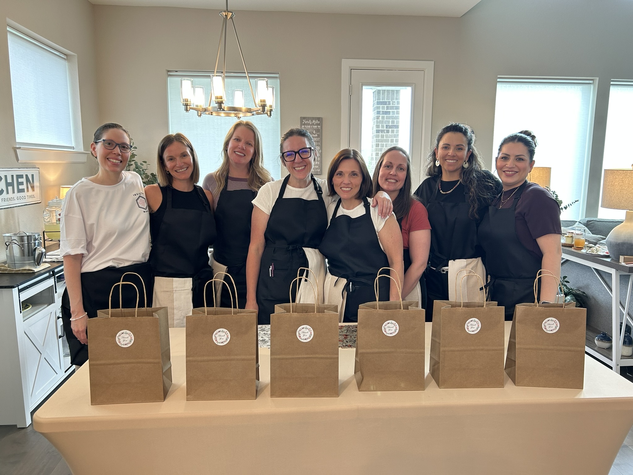 Jaime, Brittany, and all six guests holding their take-home bags at the end of the evening